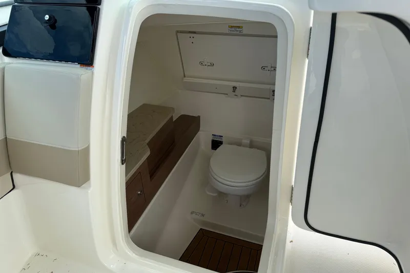 Slide: The Image of 2023 Boston Whaler 280 Vantage boat interior with compact marine toilet. - 6