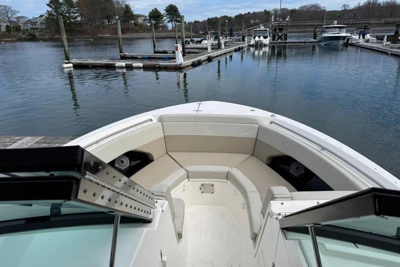 Slide: The Image of 2023 Boston Whaler 280 Vantage boat docked at a serene marina. - 8