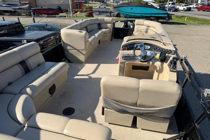 Slide: The Image of 2012 Bentley Pontoons 240 CRUISE interior with beige seating and steering console. - 10