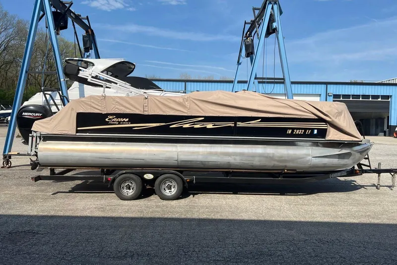 Slide: The Image of 2012 Bentley Pontoons 240 CRUISE covered on trailer, parked outdoors near blue building. - 15