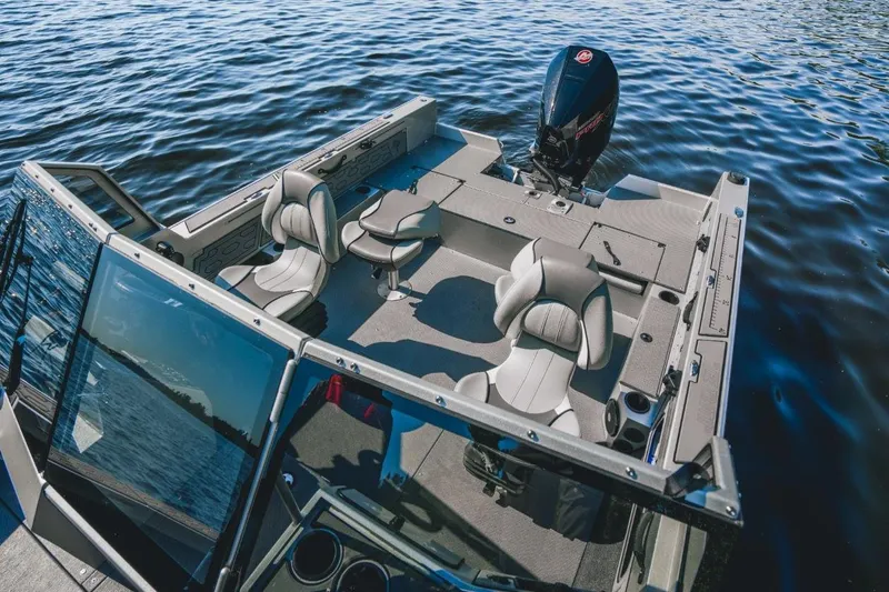 Slide: The Image of 2026 KingFisher 2125 Arrow Sport boat with sleek seating on calm water. - 10