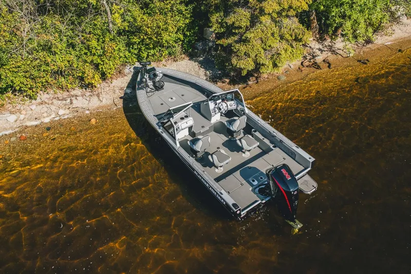 Slide: The Image of 2026 KingFisher 2125 Arrow Sport boat docked on a scenic shoreline. - 14