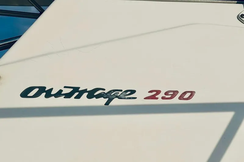 Slide: The Image of Close-up of 2002 Boston Whaler 290 Outrage boat logo on white surface. - 10