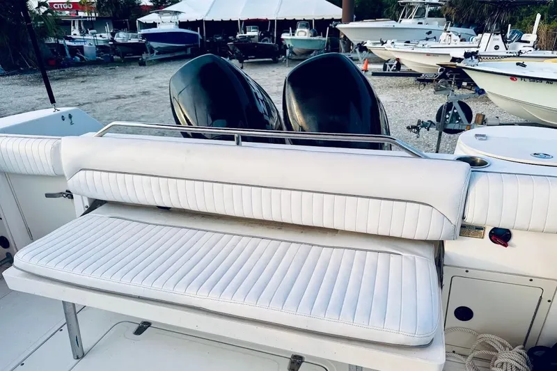Slide: The Image of 2002 Boston Whaler 290 Outrage boat with white seating and dual engines in a marina. - 26