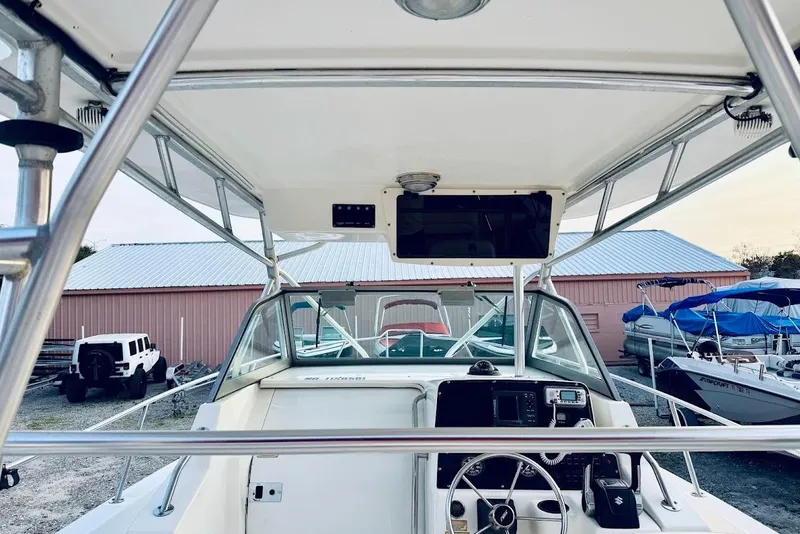Slide: The Image of 2002 Boston Whaler 290 Outrage boat cockpit with steering wheel and control panel. - 28