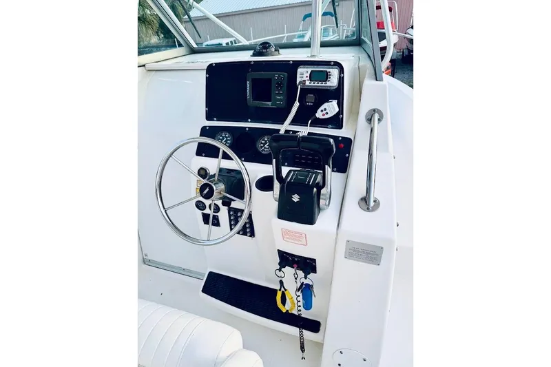 Slide: The Image of 2002 Boston Whaler 290 Outrage helm with steering wheel and control panel. - 29