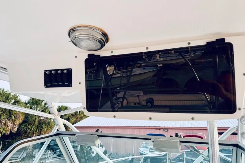 Slide: The Image of 2002 Boston Whaler 290 Outrage boat interior with control panel and overhead light. - 32