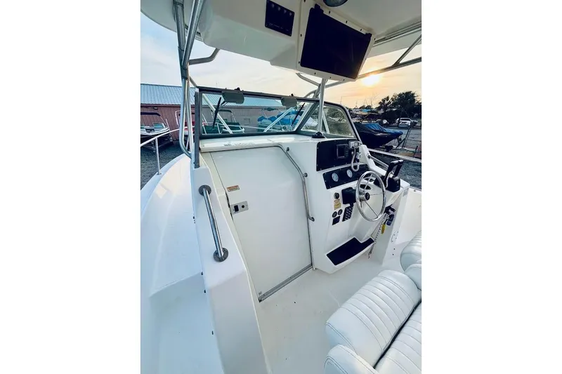 Slide: The Image of 2002 Boston Whaler 290 Outrage boat cockpit with steering wheel and control panel. - 35