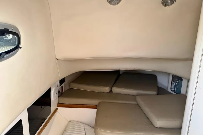 Slide: The Image of Interior cabin of a 2002 Boston Whaler 290 Outrage, featuring cushioned seating and compact design. - 47