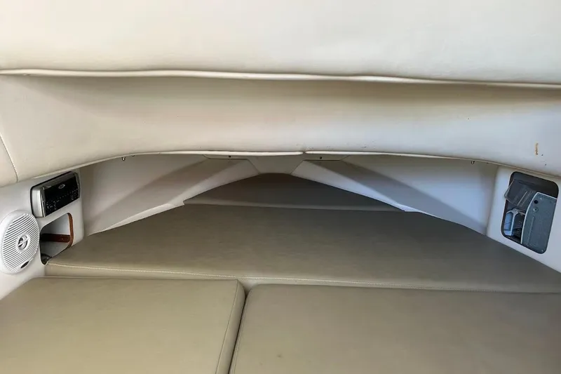 Slide: The Image of Interior cabin of 2002 Boston Whaler 290 Outrage, featuring cushioned seating and audio system. - 53