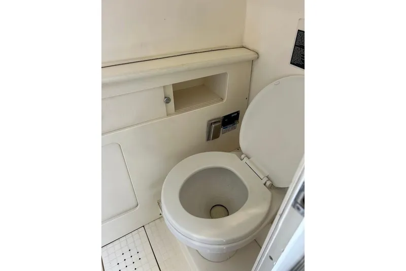 Slide: The Image of 2002 Boston Whaler 290 Outrage boat toilet interior, featuring compact marine design. - 55