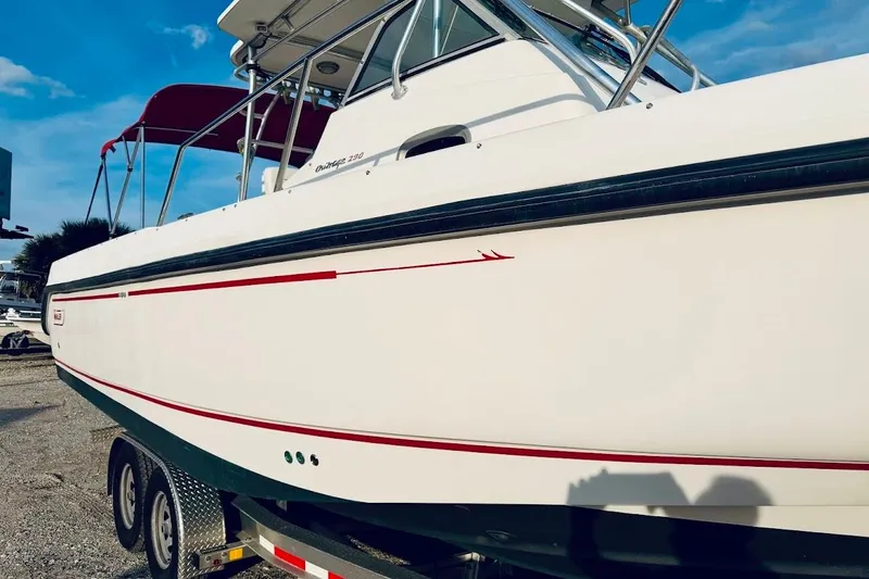 Slide: The Image of 2002 Boston Whaler 290 Outrage boat on trailer, featuring sleek white and red design. - 8