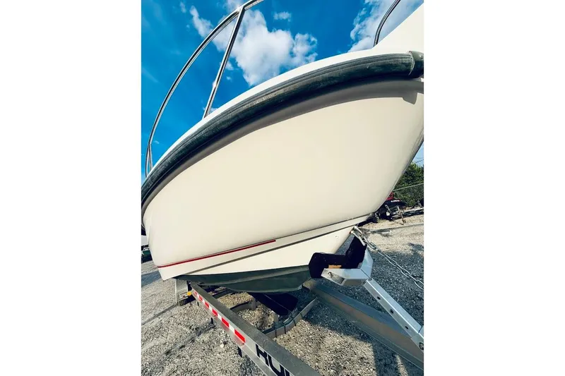 Slide: The Image of 2002 Boston Whaler 290 Outrage boat on trailer under blue sky. - 9