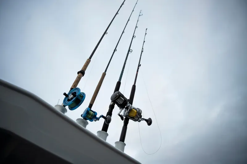 Slide: The Image of Fishing rods on a 2026 KingFisher 23 XAC boat against cloudy sky. - 14