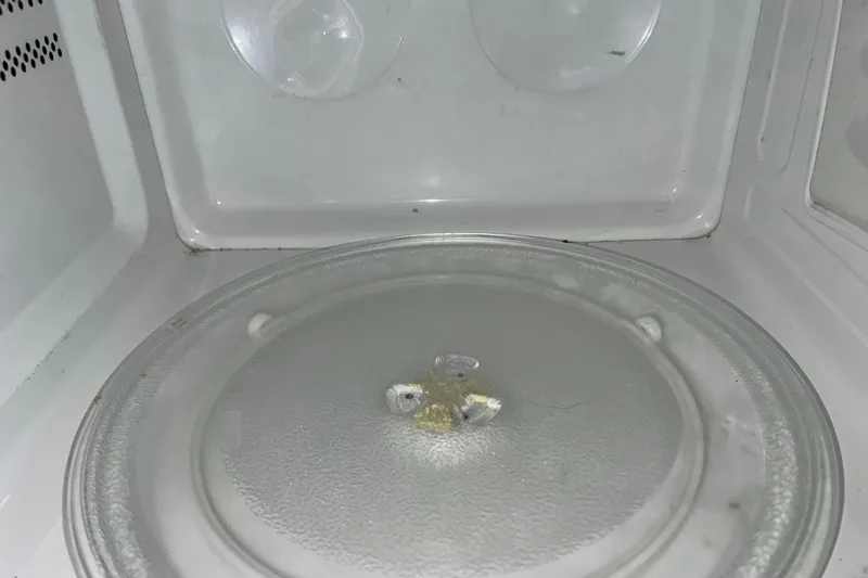 Slide: The Image of Empty microwave interior with glass turntable and slight residue. - 13