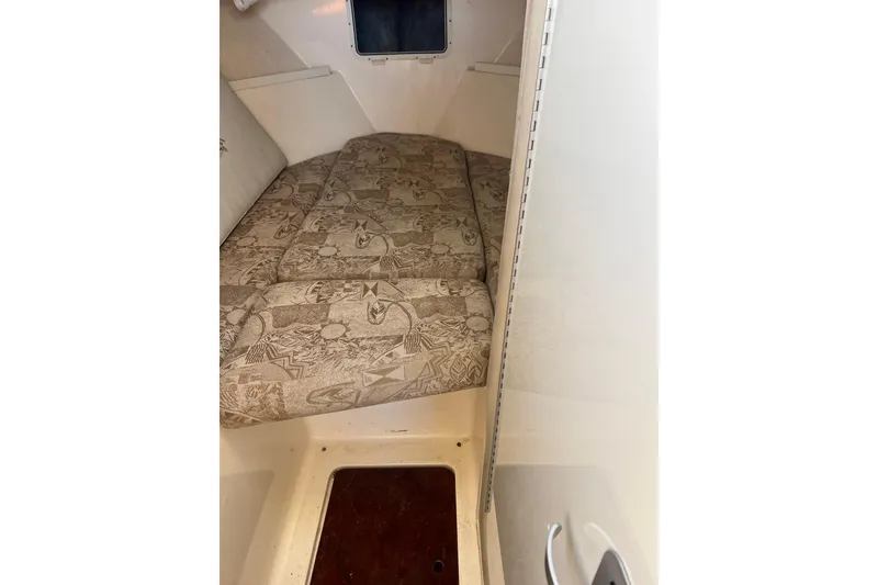 Slide: The Image of 2005 Shamrock 270 Mackinaw cabin interior with patterned cushions and compact design. - 20