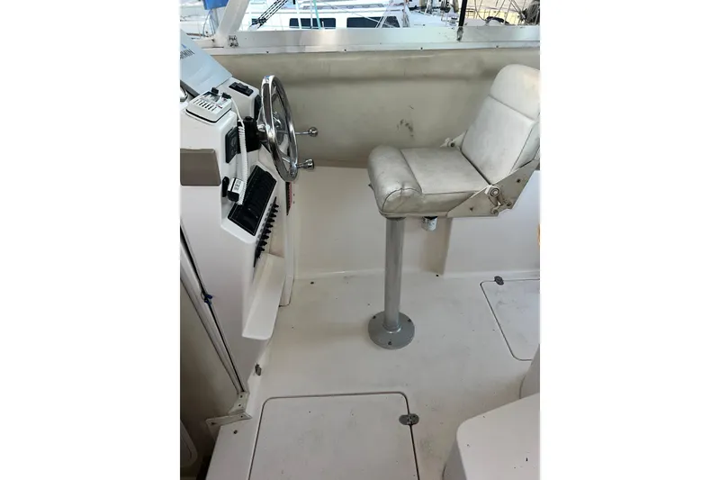 Slide: The Image of 2005 Shamrock 270 Mackinaw boat helm with steering wheel and cushioned seat. - 23