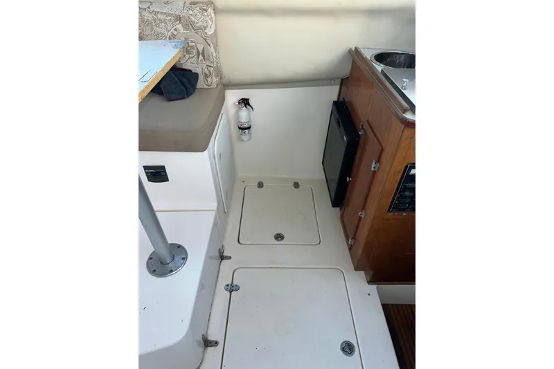 Slide: The Image of Interior of 2005 Shamrock 270 Mackinaw boat with seating, table, and kitchenette. - 24