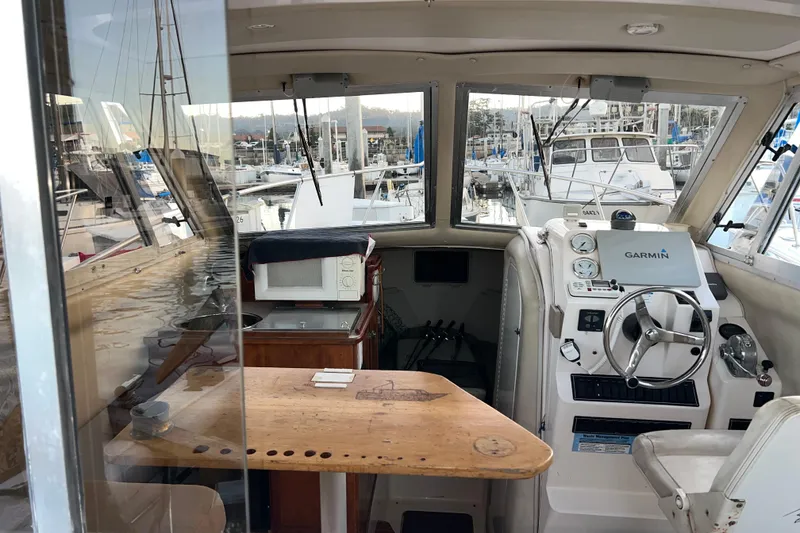 Slide: The Image of Interior of a 2005 Shamrock 270 Mackinaw boat with steering wheel and navigation equipment. - 4