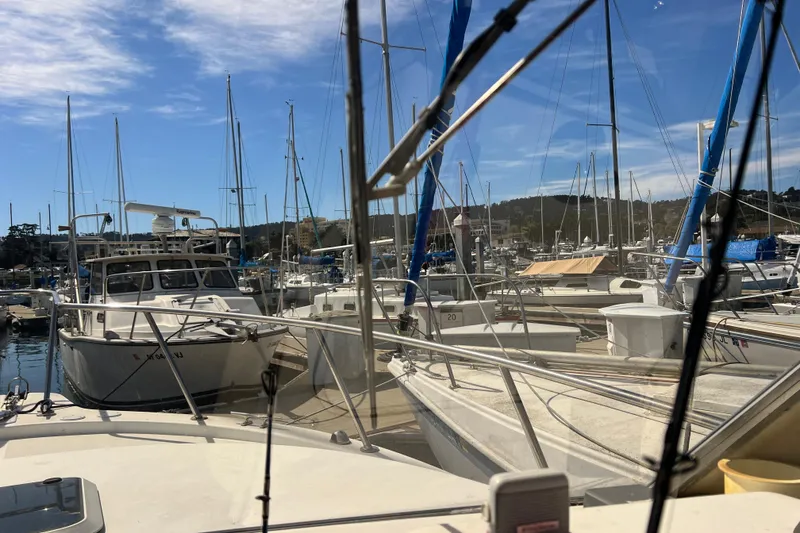 Slide: The Image of Boats docked at a marina under a clear blue sky, featuring a 2005 Shamrock 270 Mackinaw. - 9