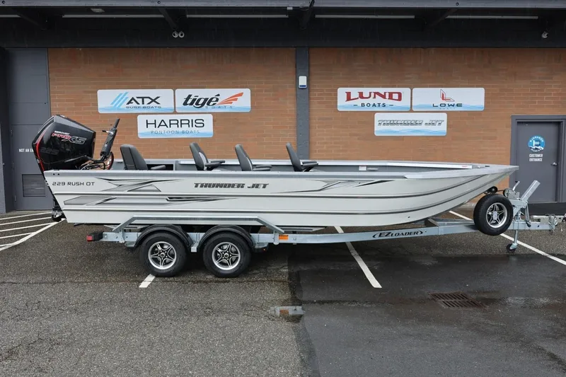 The Image of 2026 Thunder Jet 229 Rush OT boat on trailer, parked outside dealership. - 1
