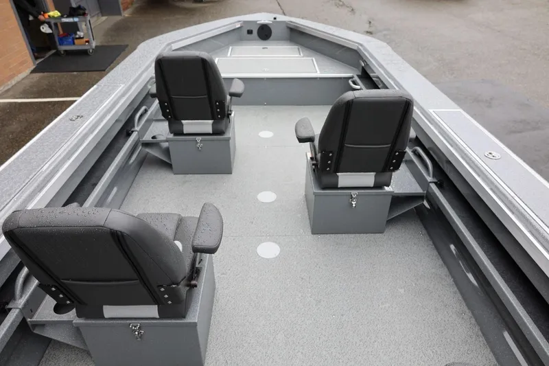 Slide: The Image of 2026 Thunder Jet 229 Rush OT boat interior with three black seats and gray flooring. - 22