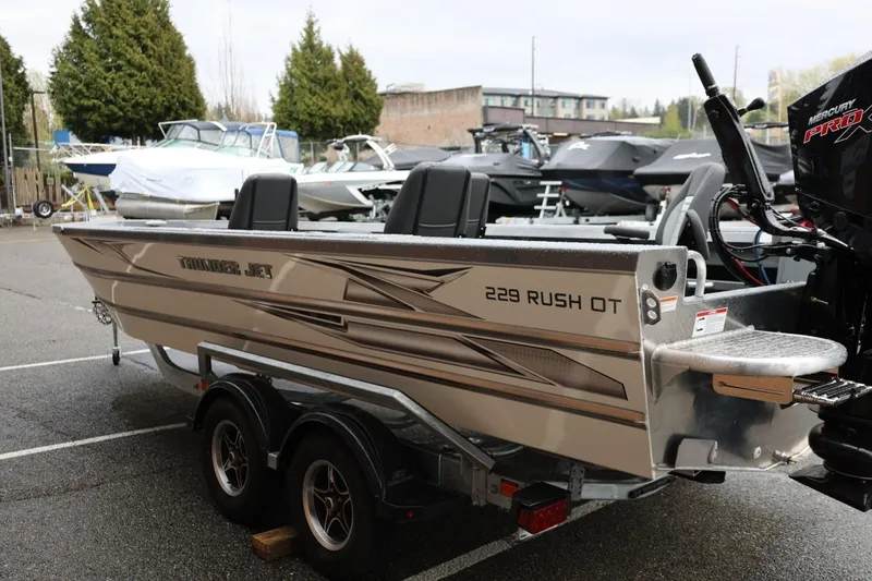 Slide: The Image of 2026 Thunder Jet 229 Rush OT boat on trailer in parking lot. - 6