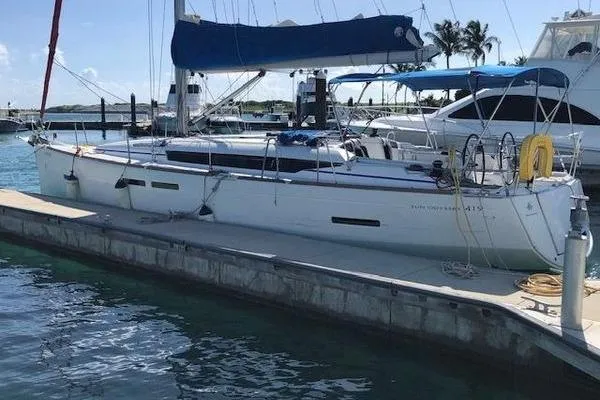 The Image of 2018 Jeanneau Sun Odyssey 419 sailboat docked at marina with blue sail cover. - 0