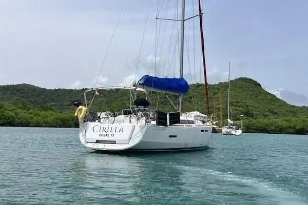 Slide: The Image of 2018 Jeanneau Sun Odyssey 419 sailboat on calm water with lush green hills. - 18