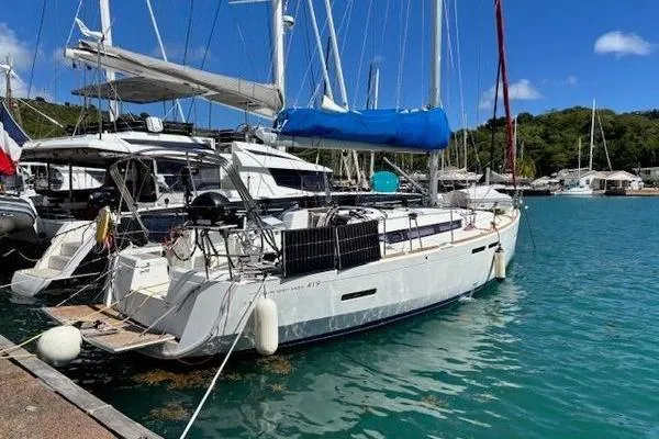 Slide: The Image of 2018 Jeanneau Sun Odyssey 419 sailboat docked in a marina, clear blue water. - 19