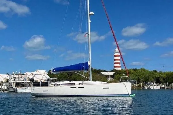 Slide: The Image of 2018 Jeanneau Sun Odyssey 419 sailboat near a lighthouse on a sunny day. - 2