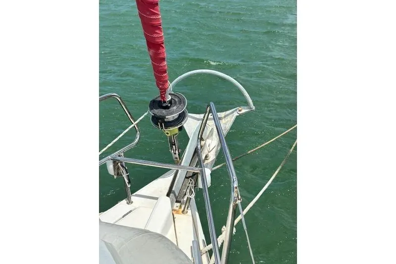 Slide: The Image of Bow of 2018 Jeanneau Sun Odyssey 419 sailboat with red sail furler on green water. - 21