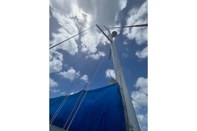 Slide: The Image of Sailboat mast and blue sail of 2018 Jeanneau Sun Odyssey 419 against cloudy sky. - 22