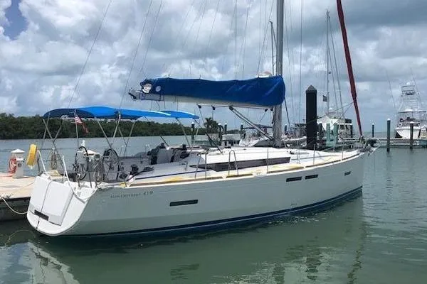 Slide: The Image of 2018 Jeanneau Sun Odyssey 419 sailboat docked in a marina under cloudy skies. - 4