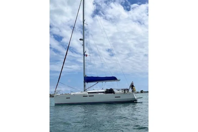 Slide: The Image of 2018 Jeanneau Sun Odyssey 419 sailboat on calm water under a partly cloudy sky. - 6