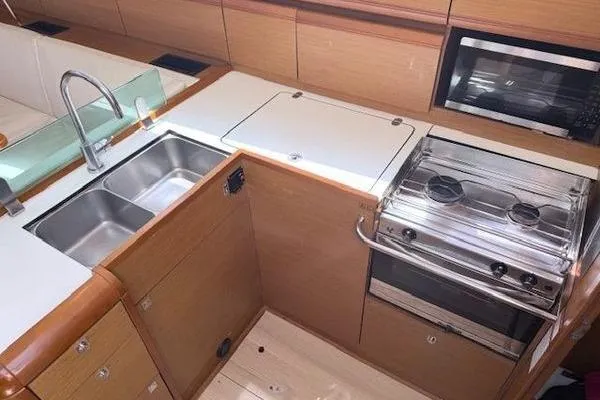 Slide: The Image of 2018 Jeanneau Sun Odyssey 419 yacht kitchen with stove, sink, and microwave. - 8