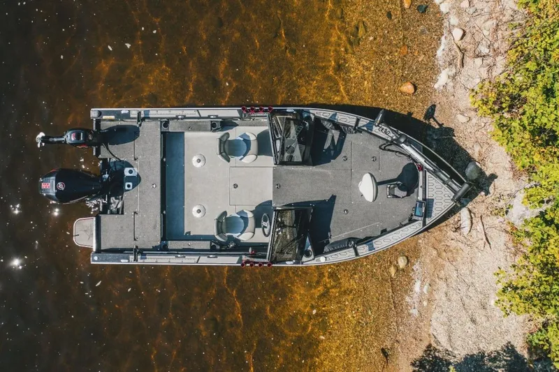 Slide: The Image of Aerial view of 2026 KingFisher 1925 Arrow Sport boat docked by a rocky shoreline. - 5