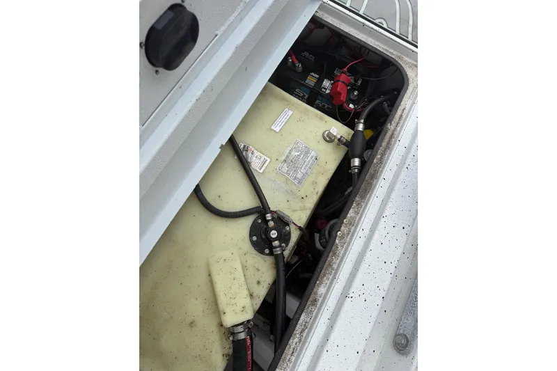 Slide: The Image of 2022 Xpress H20B Bay boat's open compartment showing fuel tank and wiring. - 13
