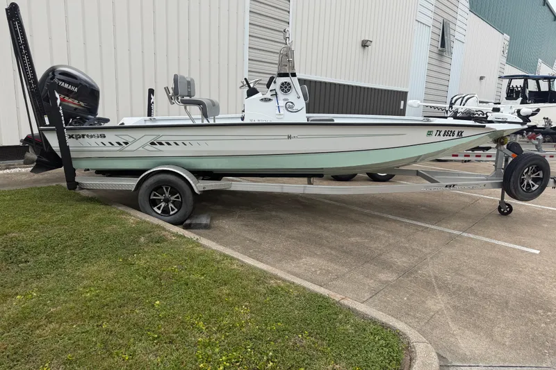 Slide: The Image of 2022 Xpress H20B Bay boat on trailer, parked outside a building. - 4