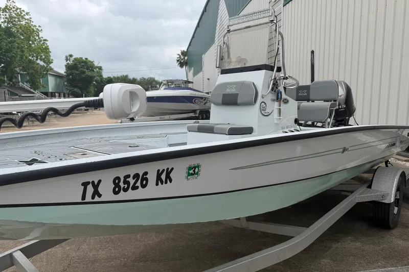 Slide: The Image of 2022 Xpress H20B Bay boat on trailer, parked outdoors near a building. - 8