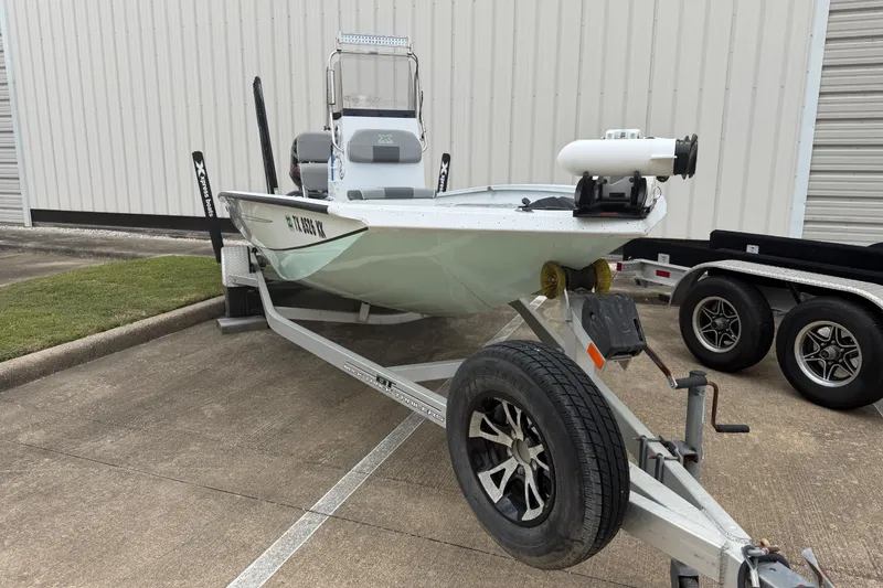 Slide: The Image of 2022 Xpress H20B Bay boat on trailer, parked outside a building. - 9