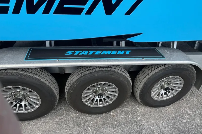 Slide: The Image of Blue 2025 Statement 350 Open boat on trailer, showcasing sleek design and bold branding. - 12