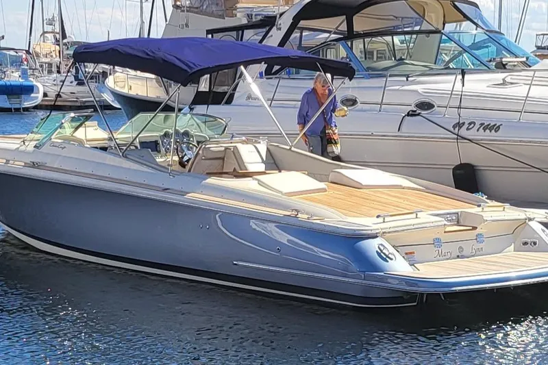 The Image of 2014 Chris Craft Corsair 34 boat docked in marina, featuring sleek design and blue canopy. - 0