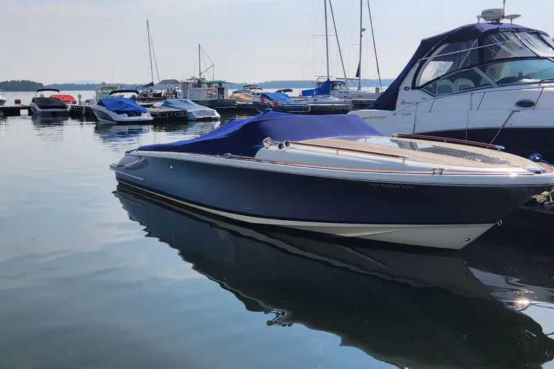 Slide: The Image of 2014 Chris Craft Corsair 34 boat docked at a marina with other vessels. - 5