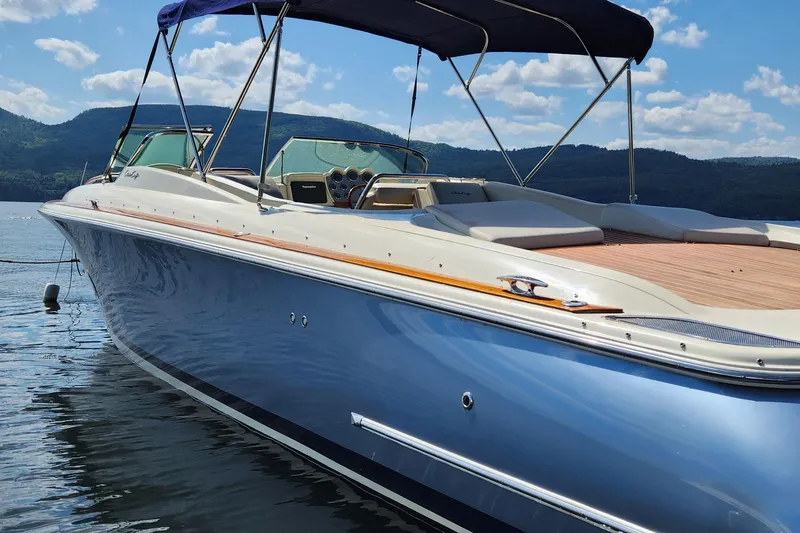 Slide: The Image of 2014 Chris Craft Corsair 34 boat on a serene lake with scenic mountain backdrop. - 8