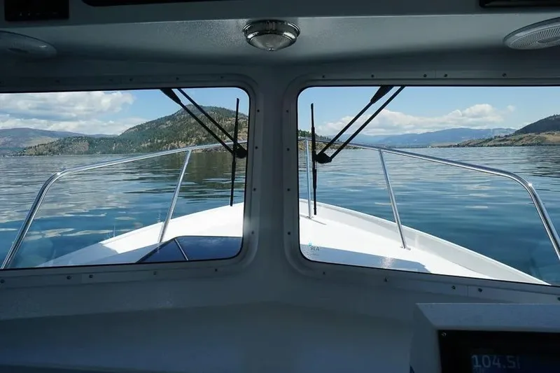 Slide: The Image of View from inside a 2026 KingFisher 2325 Coastal Express boat on a serene lake. - 15