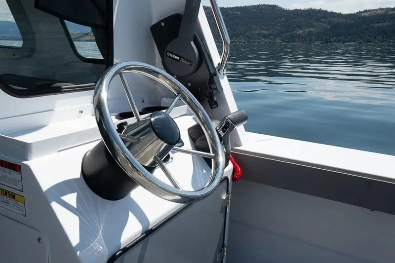 Slide: The Image of Steering wheel of 2026 KingFisher 2325 Coastal Express boat on calm water. - 3
