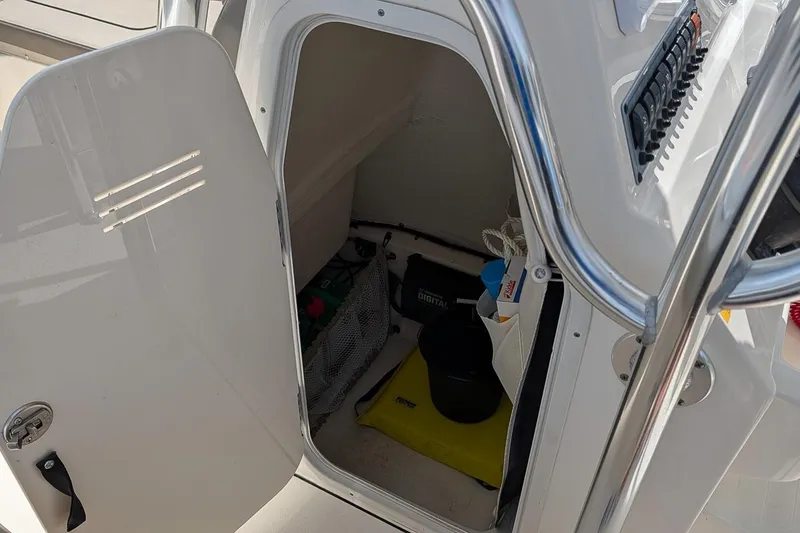Slide: The Image of Open storage compartment on a 2021 Key West 219 FS boat, showing interior items. - 17
