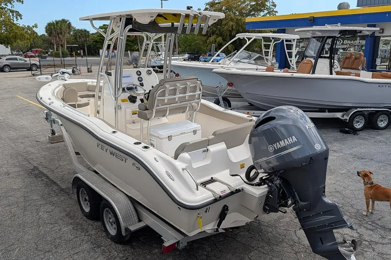 Slide: The Image of 2021 Key West 219 FS boat with Yamaha engine on trailer, parked outdoors. - 2