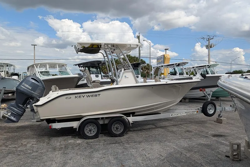 Slide: The Image of 2021 Key West 219 FS boat on trailer, parked outdoors under cloudy sky. - 4